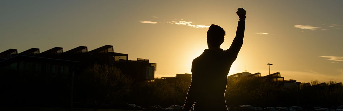 ASU student standing on the mountain and viewing sunset